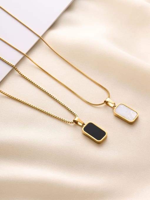 Reversible Black & White Pendant Necklace featuring a rectangular gold pendant with black and white sides on a gold chain.